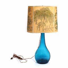 Dråbeformet bordlampe af turkisfarvet glas, med papirskærm dekoreret med motiv efter Hans Rudolf Schwarzenbach. 20. årh. H. 49,5.