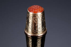 Fingerbøl i 14 kt. guld prydet med rød glasflus, 1900-tallet begyndelse